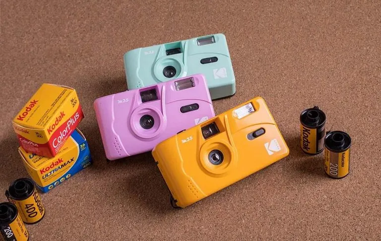 Một chiếc máy ảnh film cổ điển với cuộn phim bên cạnh